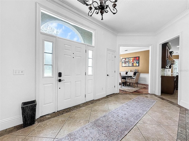 entrance foyer featuring crown molding, light tile patterned floors, a textured ceiling, and a notable chandelier