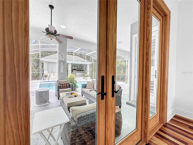 doorway to outside featuring ceiling fan, hardwood / wood-style floors, a healthy amount of sunlight, and a textured ceiling