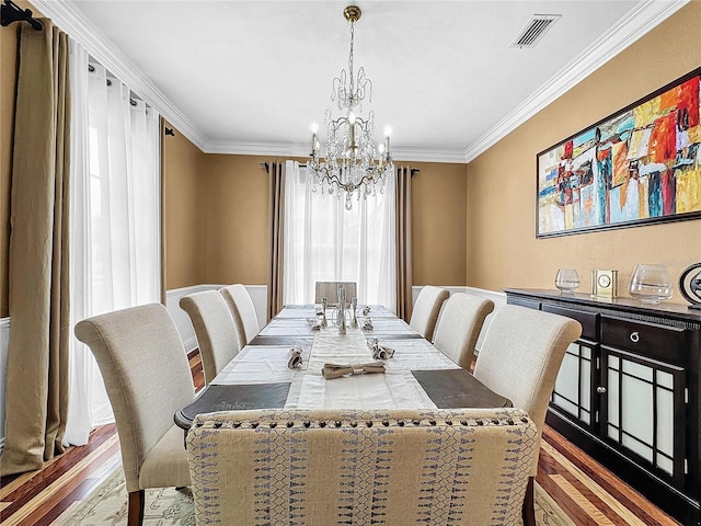 dining space featuring a notable chandelier, wood-type flooring, and crown molding