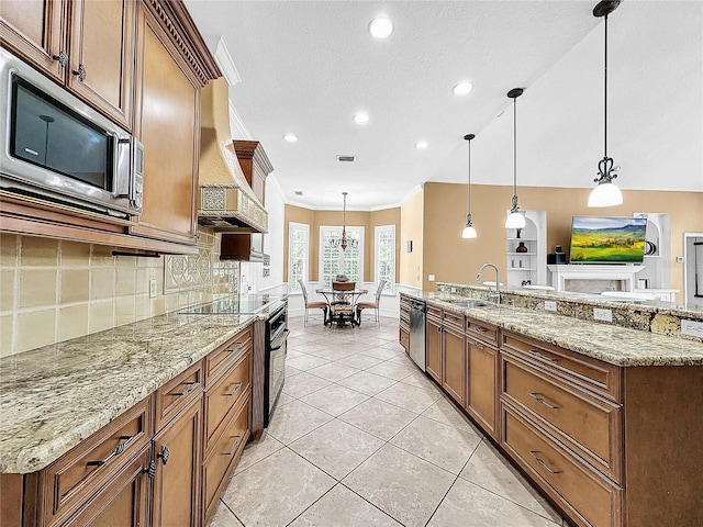 kitchen featuring sink, hanging light fixtures, light tile patterned floors, appliances with stainless steel finishes, and light stone counters