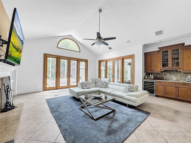 living room with wine cooler, french doors, light tile patterned floors, and high vaulted ceiling