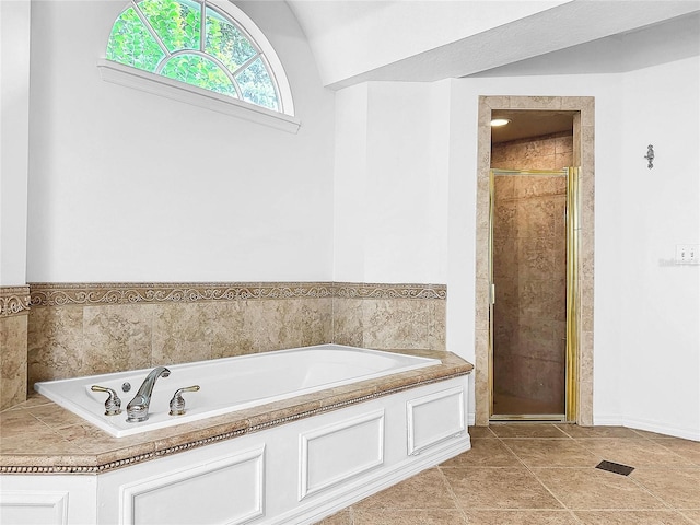 bathroom with shower with separate bathtub, vaulted ceiling, and tile patterned floors