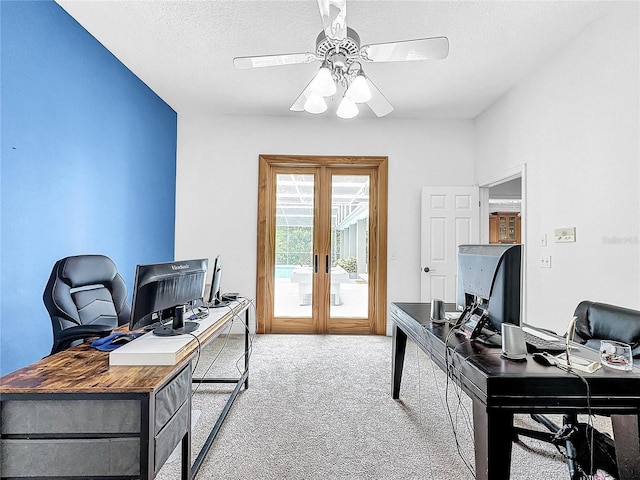 carpeted home office with ceiling fan, french doors, and a textured ceiling