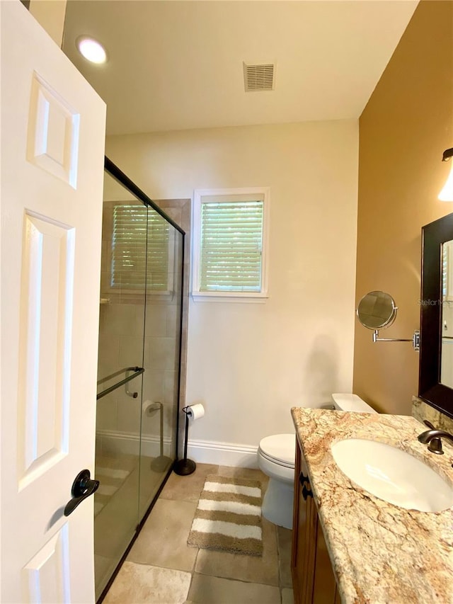 bathroom featuring tile patterned flooring, vanity, an enclosed shower, and toilet