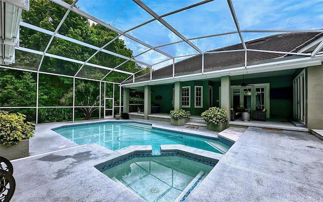 view of pool featuring ceiling fan, a patio area, an in ground hot tub, and glass enclosure