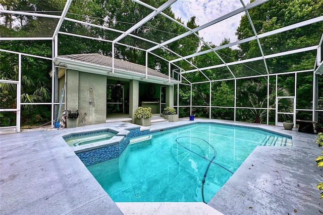 view of pool with an in ground hot tub, a patio, and glass enclosure