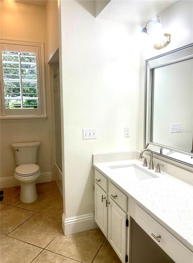 full bathroom with tile patterned floors, vanity, bath / shower combo with glass door, and toilet