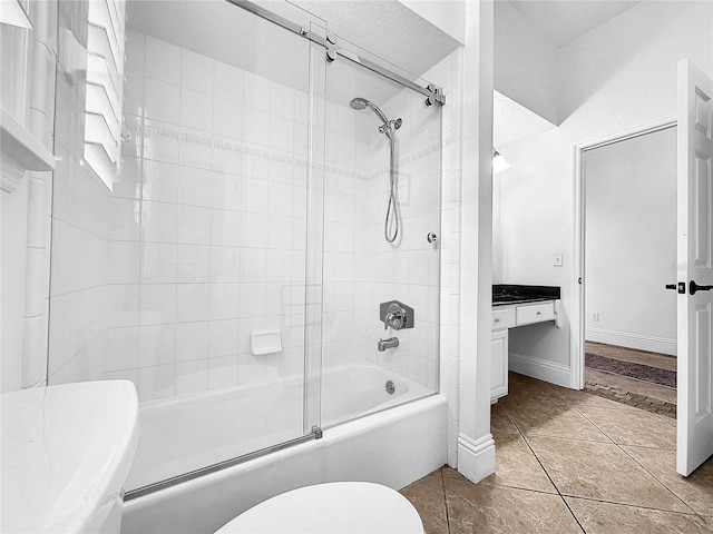 bathroom featuring tile patterned floors, bath / shower combo with glass door, and toilet