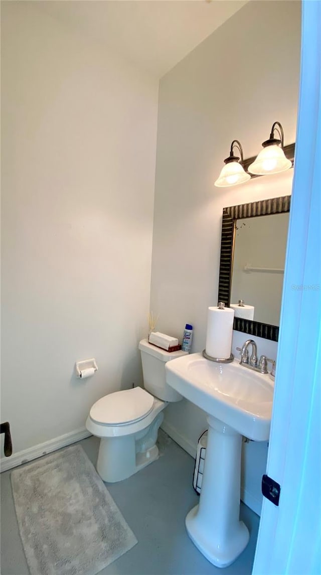 bathroom featuring concrete flooring and toilet