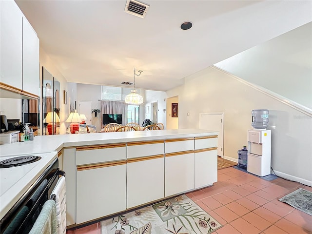 kitchen featuring kitchen peninsula, hanging light fixtures, white cabinets, and light tile floors