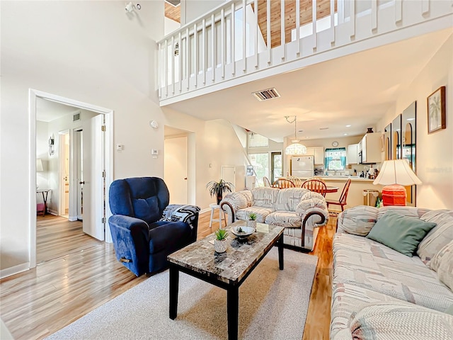 living room featuring light hardwood / wood-style floors and a towering ceiling