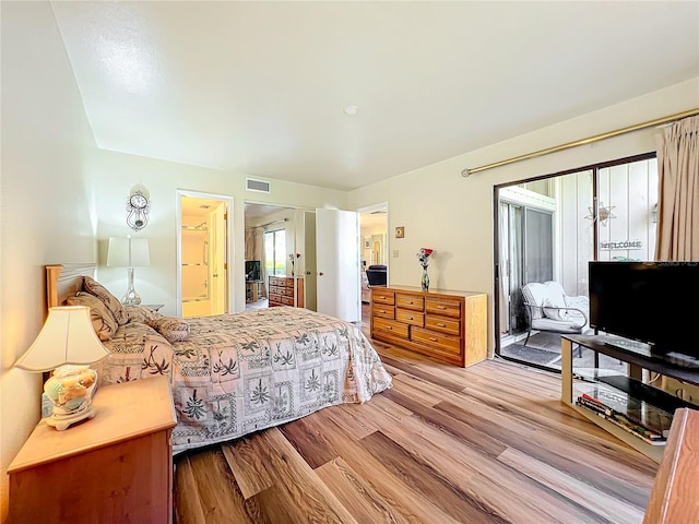 bedroom with ensuite bathroom and light wood-type flooring