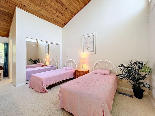 bedroom with a closet, wood ceiling, and high vaulted ceiling