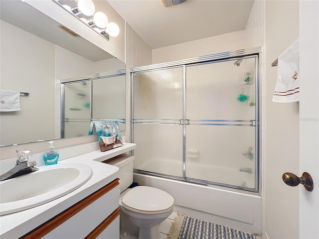 full bathroom with enclosed tub / shower combo, toilet, vanity with extensive cabinet space, and tile floors