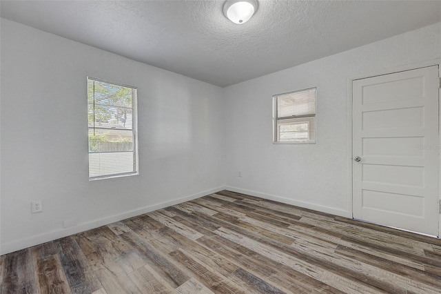 empty room featuring a textured ceiling and hardwood / wood-style flooring