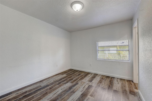 empty room with a textured ceiling and hardwood / wood-style flooring