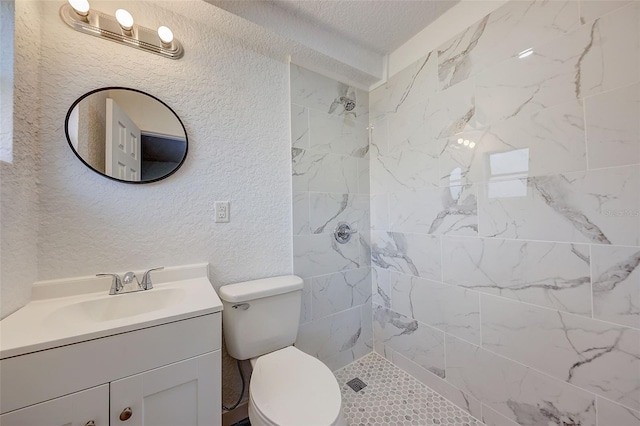 bathroom featuring vanity, toilet, and tiled shower