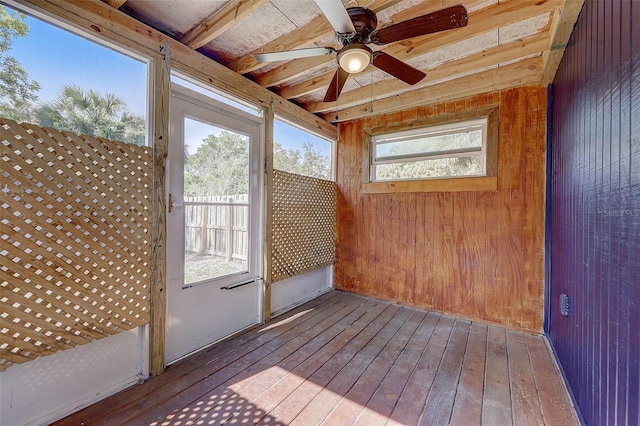 unfurnished sunroom featuring ceiling fan and beamed ceiling