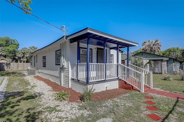 view of front of property featuring cooling unit, a front lawn, and a porch