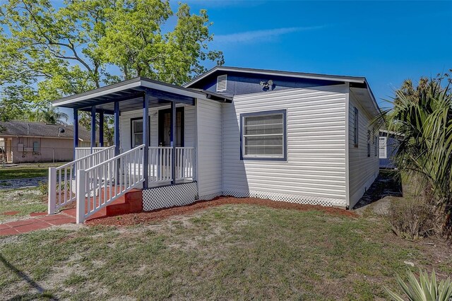 view of front of house with covered porch and a front lawn