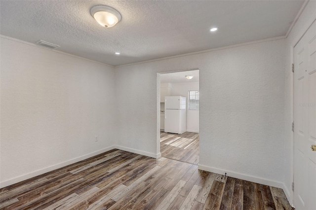 unfurnished room featuring hardwood / wood-style flooring, ornamental molding, and a textured ceiling