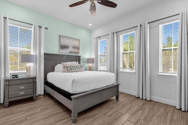 bedroom with ceiling fan, light wood-type flooring, and multiple windows