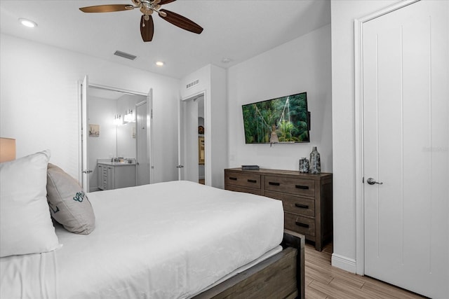 bedroom with ensuite bath, ceiling fan, and light wood-type flooring