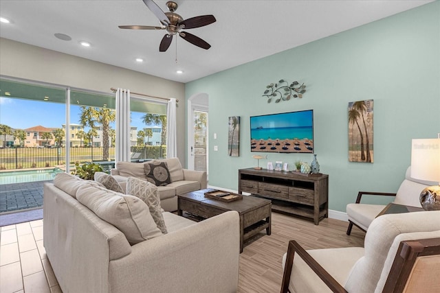 living room with ceiling fan and light wood-type flooring