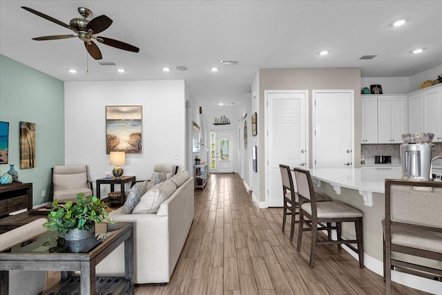 living room featuring light hardwood / wood-style floors and ceiling fan