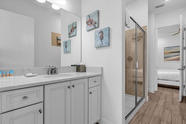 bathroom featuring an enclosed shower, vanity with extensive cabinet space, and ceiling fan