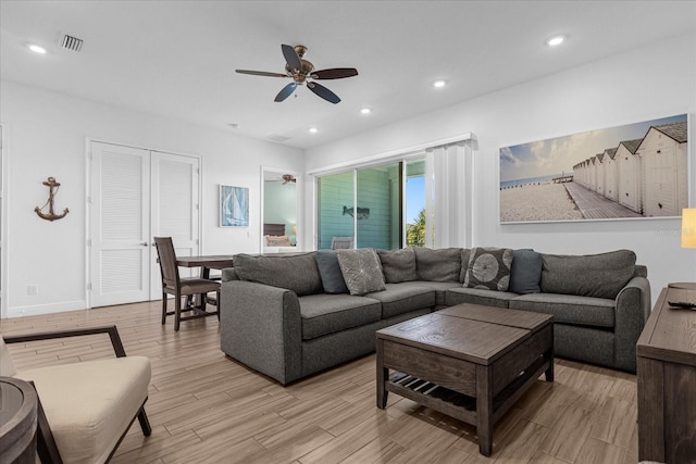 living room with ceiling fan and light hardwood / wood-style flooring