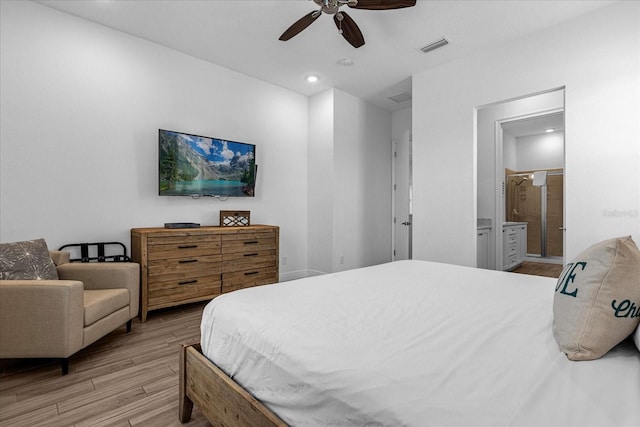 bedroom with light hardwood / wood-style flooring, ceiling fan, and ensuite bath