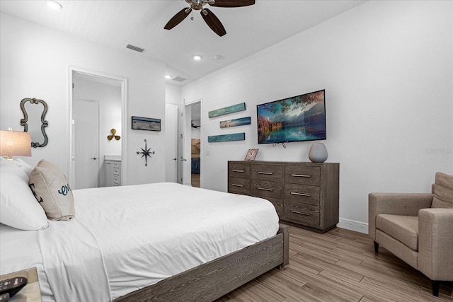 bedroom with connected bathroom, ceiling fan, and light wood-type flooring