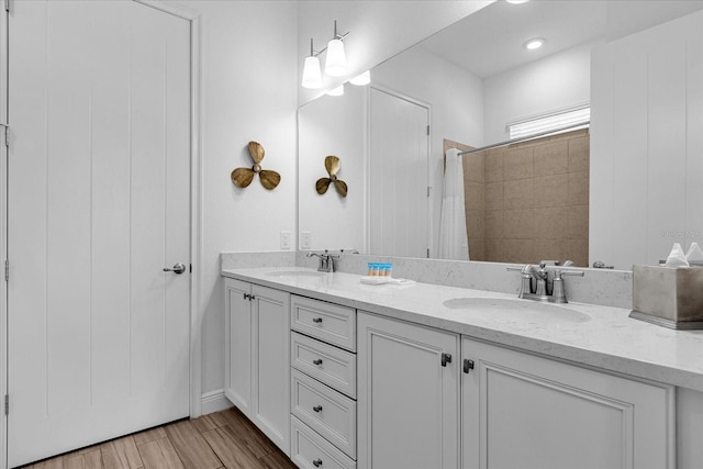 bathroom with double vanity and wood-type flooring