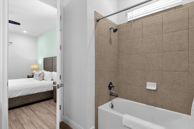 bathroom with tiled shower / bath and hardwood / wood-style floors