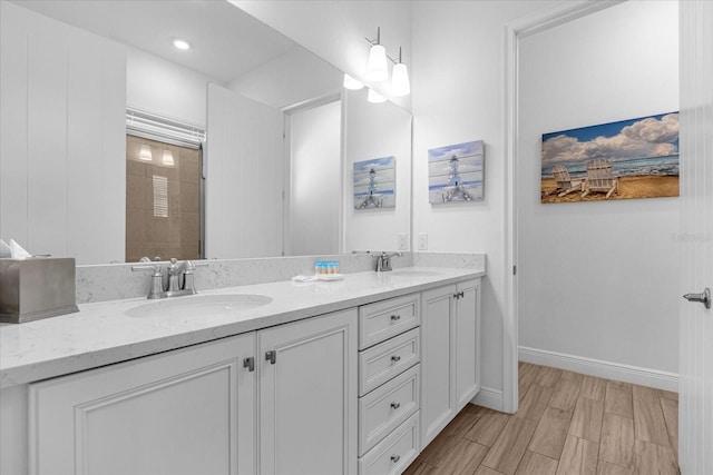 bathroom with dual vanity and hardwood / wood-style flooring