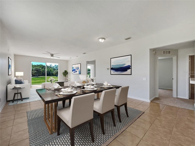 dining area with light colored carpet and ceiling fan