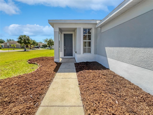 doorway to property featuring a yard