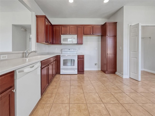 kitchen with light tile flooring, white appliances, and sink