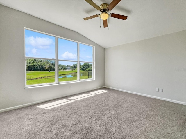 unfurnished room featuring carpet flooring, ceiling fan, a wealth of natural light, lofted ceiling, and a water view