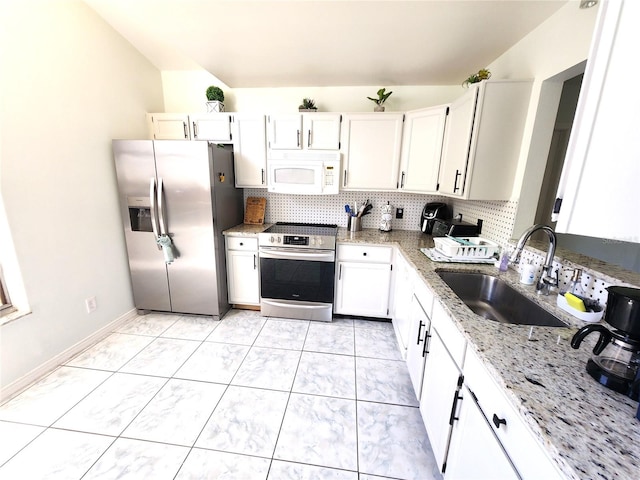 kitchen with sink, light stone counters, white cabinets, backsplash, and stainless steel appliances