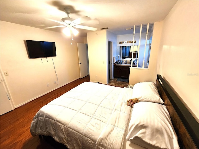 bedroom with ensuite bath, ceiling fan, and dark hardwood / wood-style flooring