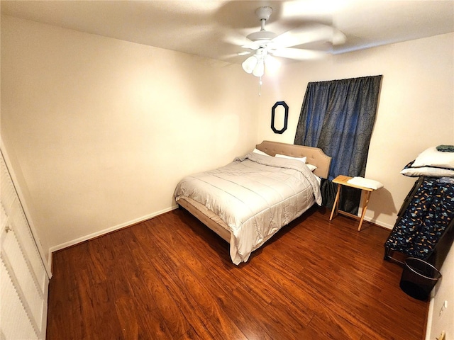 bedroom featuring dark wood-style flooring, a ceiling fan, and baseboards