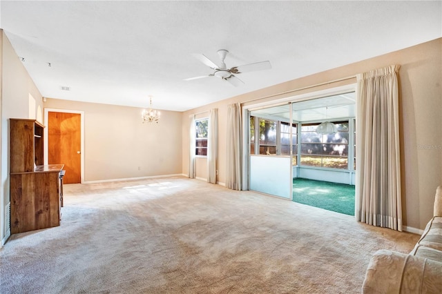 carpeted empty room with ceiling fan with notable chandelier