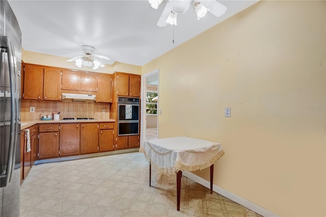 kitchen featuring double oven, backsplash, light tile floors, gas cooktop, and ceiling fan