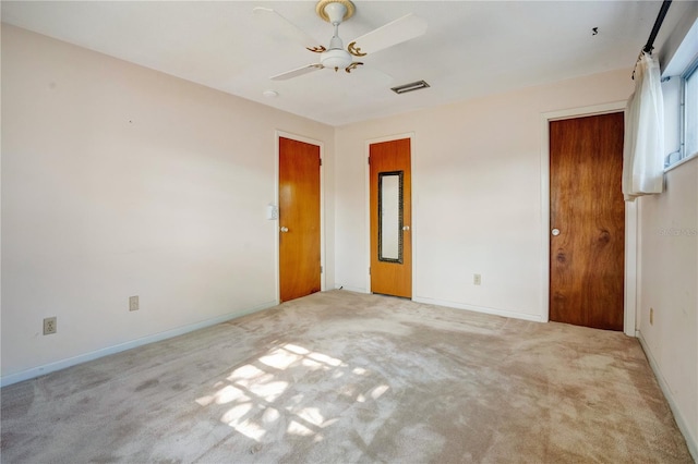 carpeted spare room featuring ceiling fan