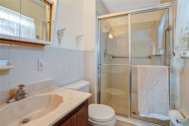 bathroom with vanity, tile walls, backsplash, a shower with shower door, and toilet