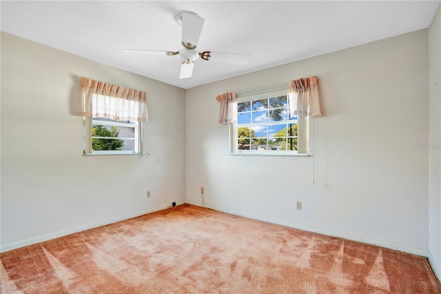 unfurnished room with a wealth of natural light, ceiling fan, and carpet flooring