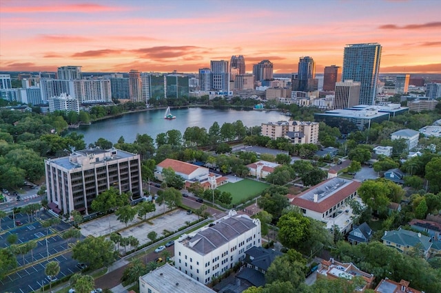 aerial view at dusk featuring a water view