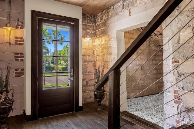 interior space with wood ceiling, dark hardwood / wood-style flooring, and brick wall